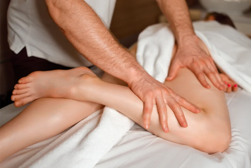 Person receiving a professional massage on a portable massage bed in an apartment in Home Massage in JVC Dubai