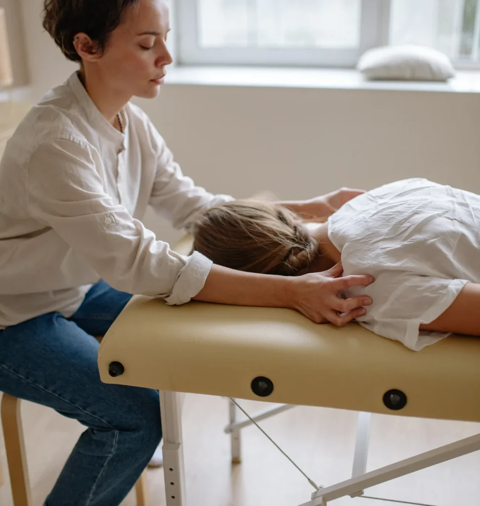 Person receiving a professional massage on a portable massage bed in an apartment in Home Massage in Person receiving a professional massage on a portable massage bed in an apartment in Home Massage in JVT Dubai