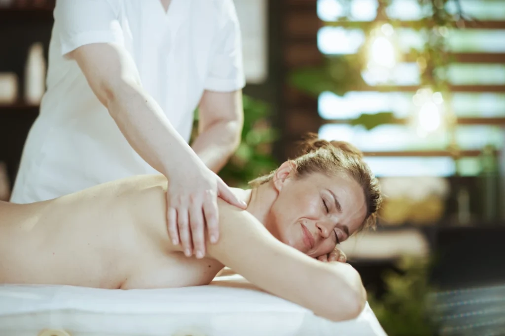 Person receiving a professional massage on a portable massage bed in an apartment in Dubai Marina.