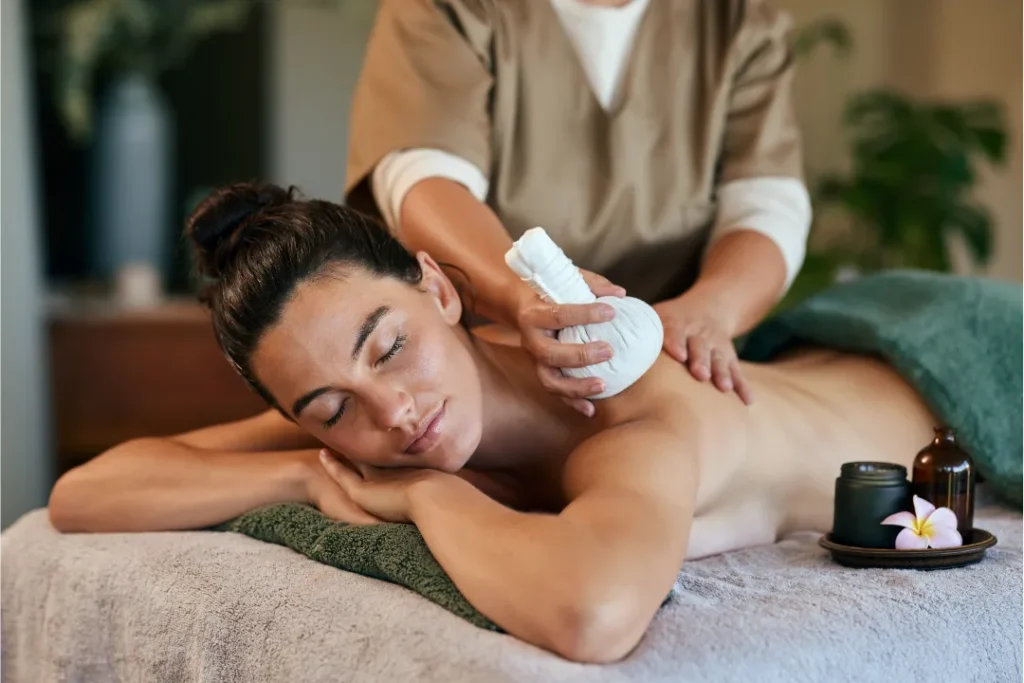 Person receiving a professional massage on a portable massage bed in an apartment in Dubai JBR.
