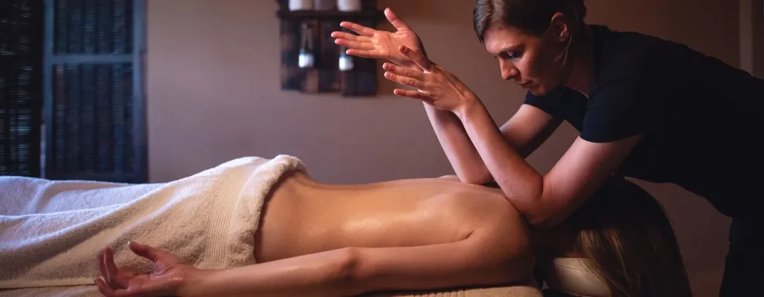 Person receiving a professional massage on a portable massage bed in an apartment in Home Massage in Person receiving a professional massage on a portable massage bed in an apartment in Home Massage in Arabian Ranches